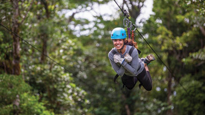 A solo traveler ziplines in Costa Rica on an Intrepid trip.